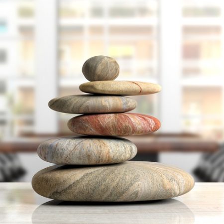 Zen stones stack on a desk, office background. 3d illustration Relaxation at the office. Zen stones stack on an office desk. 3d illustration